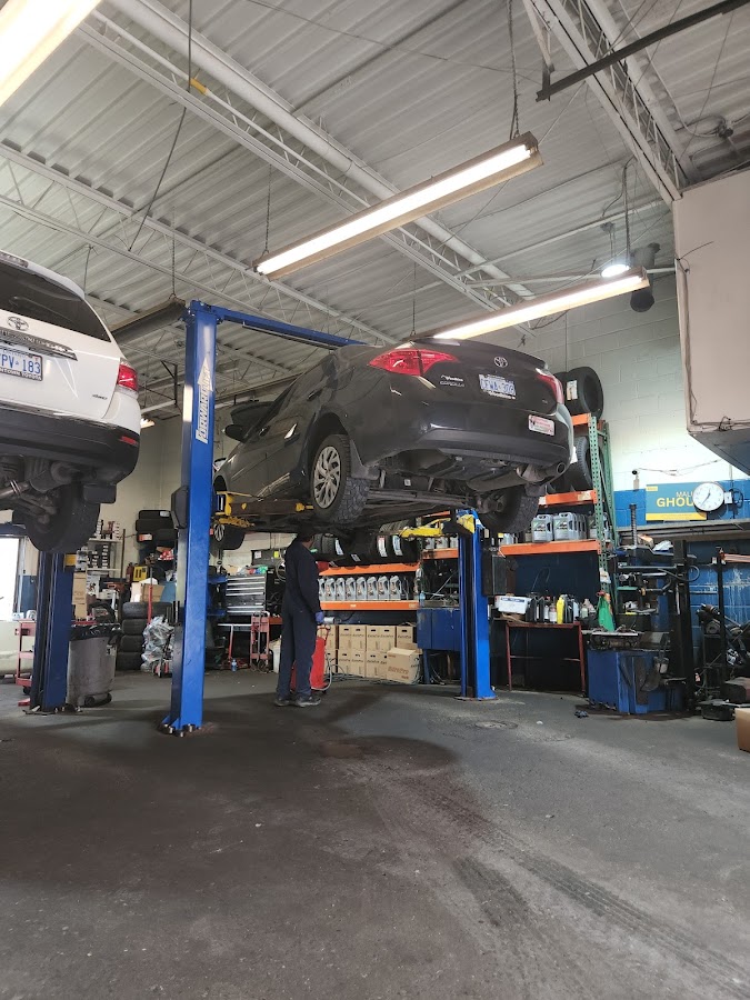 Active Auto Repairs mechanic working under a lifted car in the Toronto garage